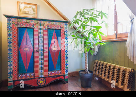 Chambre principale avec armoire ancienne en bois coloré avec point de diamant design, maison verte à côté de l'ancien radiateur de chauffage d'eau chaude dans la vieille maison. Banque D'Images