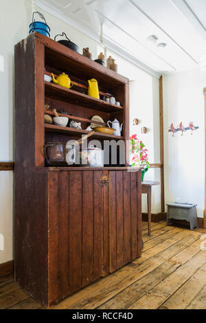 Vieux meubles anciens en buffet avec des pots et de la vaisselle dans un couloir au rez-de-chaussée dans une ancienne maison en pierre de 1835 Banque D'Images