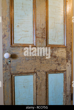Ancienne porte de placard en bois finition a souligné avec bleu et marron en peinture à l'étage supérieur de chambre à l'intérieur d'une vieille maison en pierre de 1835 Banque D'Images