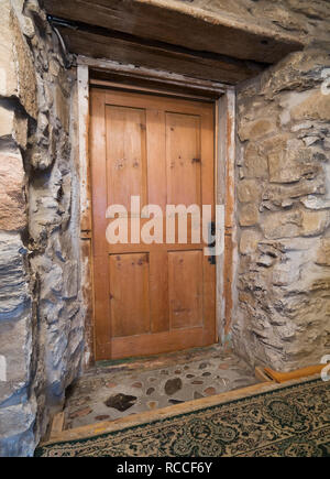 Porte de bois dans le grenier menant à une chambre mansardée à l'intérieur d'un ancien vers 1752 Maison en pierre de style Canadiana Banque D'Images