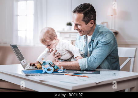 Heureux Jeune homme tenant son bébé Banque D'Images