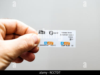 PARIS, FRANCE - DEC 21, 2018 : Man holding contre fond blanc avec ticket de métro RER Aéroport Charles de gaulle terminal 2 au centre de Paris Banque D'Images