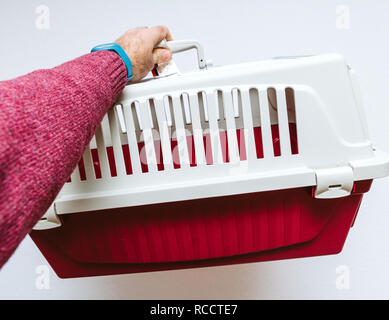 Tenir la main de l'homme contre l'animal cage pet fond blanc utilisé pour le transport de chat et de chien dans les avions et les autobus Banque D'Images