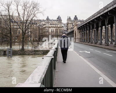 PARIS, FRANCE - Jan 30, 2018 : vue arrière de l'homme marche sur la partie pédestre de pont BirHakeim à Paris lors d'inondations de la Seine Banque D'Images