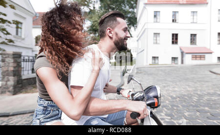 Jeune couple élégant se trouve un scooter dans la rue. Banque D'Images