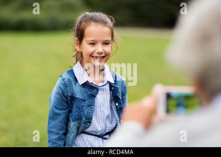 Petite fille d'être photographié à parc d'été Banque D'Images