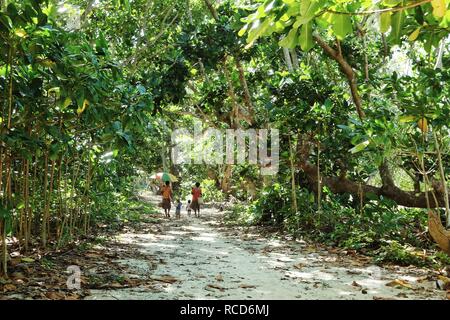 L'île de Pentecôte, Lavatmangguemu / Vanuatu - 10 Apr 2016 : la maison avec les enfants sur le chemin de la mer à côté de leur village avec un parapluie Banque D'Images