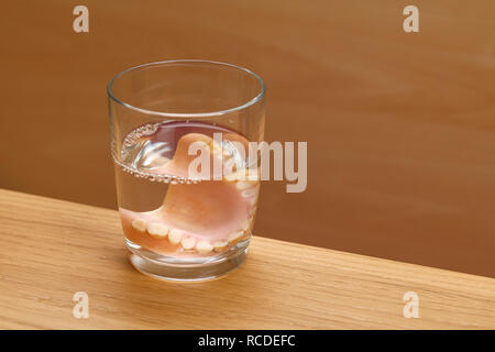 Un ensemble de fausses dents dans un verre d'eau Banque D'Images