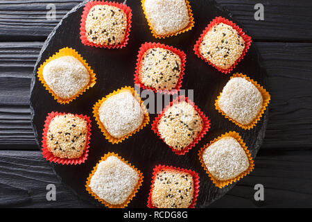 Riz japonais daifuku mochi dessert sain avec anko et de graines de sésame gros plan sur la table. haut horizontale Vue de dessus Banque D'Images