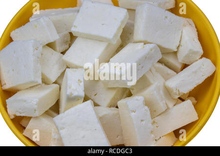 Fromages tranchés dans bol jaune sur fond blanc Banque D'Images