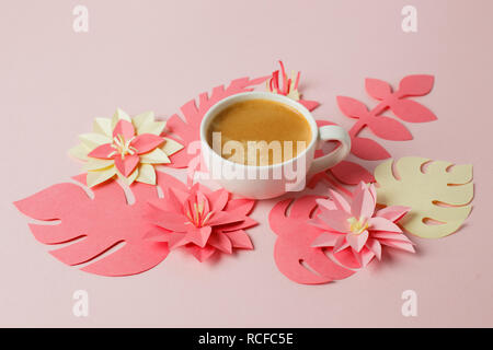 Espresso blanc sur un fond pastel rose avec un décor moderne origami papier fleurs, concept de petit-déjeuner romantique Banque D'Images