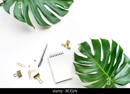 Vue de dessus de bureau avec table et feuilles monstera accessoires maquette sur fond blanc.télévision jeter design.copy space Banque D'Images