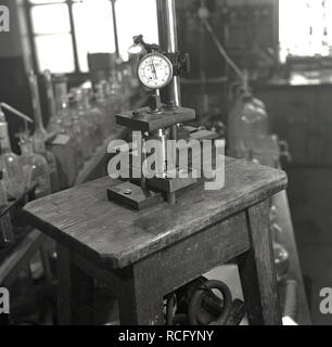 1950s, historique, laboratoire scientifique, sur un petit banc de travail en bois, un instrument « John Bull », un comparateur à cadran fixé sur la table, Leeds University, Leeds, Angleterre, Royaume-Uni. L'équipement d'essai « John Bull » de l'époque a été fabriqué par British Indicators Ltd de Pickford Rd, St Albans, Angleterre, Royaume-Uni, un fabricant leader d'équipements de mesure et de jaugeage interne de précision. Banque D'Images