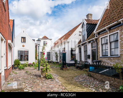 Cour historique Hofje avec de vieilles maisons blanches et la pompe à eau dans la ville de Den Burg Weverstraat sur île de Texel, Pays-Bas Banque D'Images