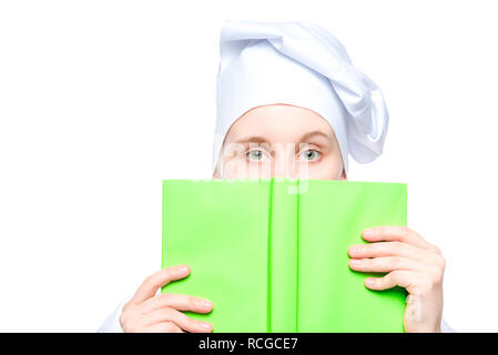 Portrait d'un cuisinier dans un bouchon close-up, le visage recouvert d'un livre de recettes photo concept isolé sur fond blanc Banque D'Images