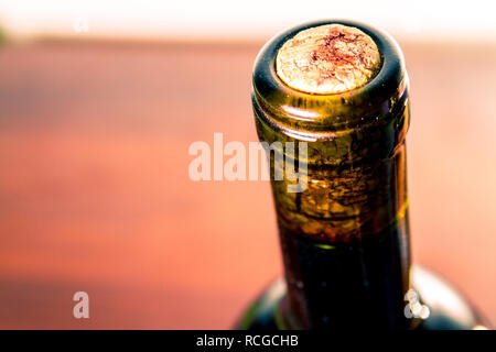 Bouteille de vin rouge foncé sur une table en bois sombre avec le liège dans l'accent Banque D'Images