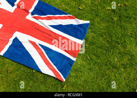 Union Jack sur l'herbe verte. Grande-bretagne et Irlande du Nord drapeau dans un parc. Serviette de plage avec le pavillon du Royaume-Uni pour un pique-nique. Banque D'Images