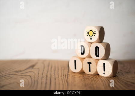 Cube avec idée symbole et le message 'Do it' sur fond de bois Banque D'Images