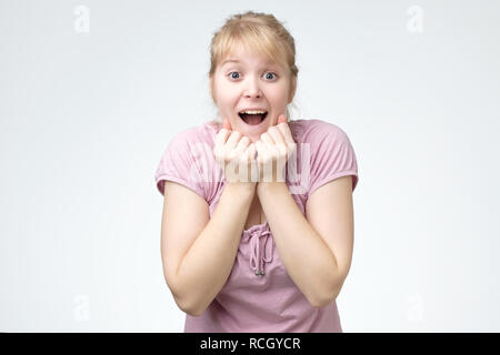 Young woman smiling très heureux surpris main dans la main près de tête étant étonné sur fond blanc. Banque D'Images