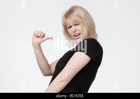 Portrait de jeune femme pointant sur elle-même se défendre verbalement, ayant une certaine perplexité, et l'expression perplexe sur son visage, en disant : Qui moi. Banque D'Images