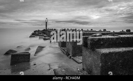 Photo en noir et blanc des vagues se briser sur la jetée en bois ancien, Landguard Point, Felixstowe, Suffolk Banque D'Images