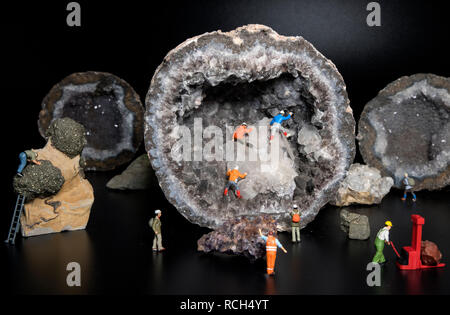 Petites marionnettes occupé avec l'exploration de grottes ou d'exploitation minière avec des cristaux de nice et geode pierre de millions d'années Banque D'Images