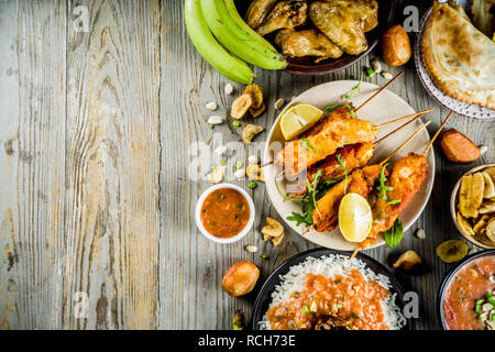 Concept alimentaire en Afrique de l'Ouest. Wset traditionnels mets africains assortiment - soupe d'arachides, de riz jollof, ailes de poulet grillées à sec, les plantains, bananes frites Banque D'Images