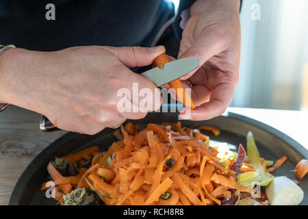 Female woman peeling mains carottes dans une cuisine domestique Banque D'Images