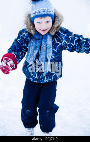 Maison de vacances actives en hiver - cute little boy patinage sur une patinoire Banque D'Images