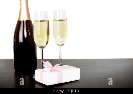 Bouteille de champagne et deux verres avec boîte-cadeau isolé en fond blanc. Banque D'Images