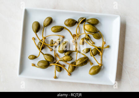 Conserves de câpres au vinaigre et prêt à manger de la plaque. L'alimentation biologique. Banque D'Images