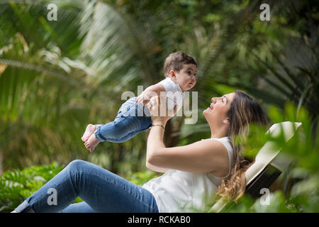 Happy woman holding nouveau fils dans le jardin Banque D'Images