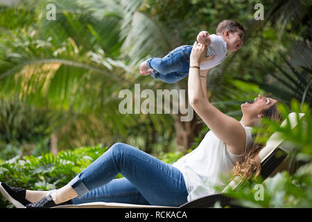 Happy woman holding nouveau fils dans le jardin Banque D'Images