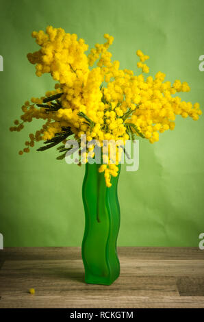 Bouquet de printemps avec mimosa et tulipes dans un vase Banque D'Images