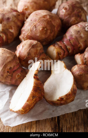 Topinambour cru close up sur fond de bois vertical. Banque D'Images