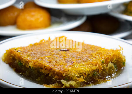 Avec dessert turc en noyer. Close up Turkish shredded wheat dessert à la pistache le remplissage Banque D'Images