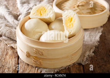 Crème anglaise à la vapeur cantonais buns libre dans un panier de bambou sur la table horizontale. Banque D'Images