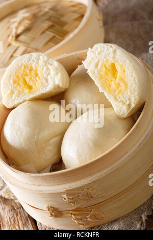 Crème onctueuse vapeur chinois Bun close-up sur la table verticale. Banque D'Images