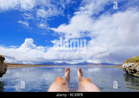 Les jambes d'un homme athlétique en thermique naturel Hot spring Polloquere Salar de Surire, salt lake, Parc National du Volcan Isluga, Chili Banque D'Images