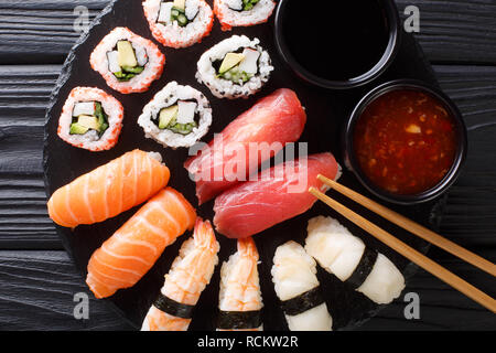 Ensemble de rouleaux japonais d'uramak nigiri et servi avec deux sauces close-up sur une plaque en ardoise. haut horizontale Vue de dessus Banque D'Images