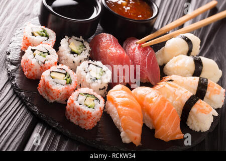 Fruits de mer restaurant traditionnel japonais, le menu photo. super haut en rouleaux de sushi frais avec le saumon, le thon, nigiri et maki servi dans la plaque noire Banque D'Images