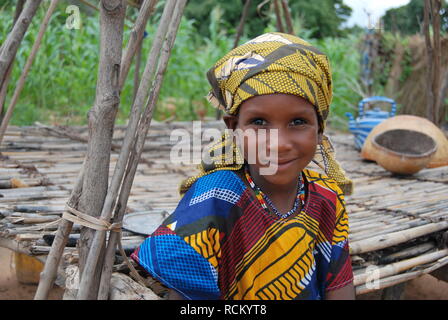 Un peu de Fulani fille devant sa famille lit en plein air au bord du champ de blé au Niger, Afrique Banque D'Images