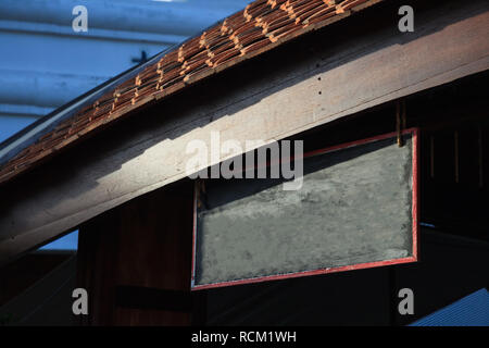 Magasin traditionnel vide/vintage retro bois pancarte avec arrière-plan de construction en bois prêt à mettre sur les noms, des signes, des messages ou logos Banque D'Images