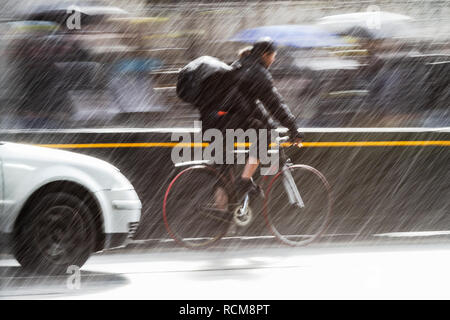 Motion Blur photo d'un cycliste dans le trafic d'une rue de ville à Heavy Rain Banque D'Images