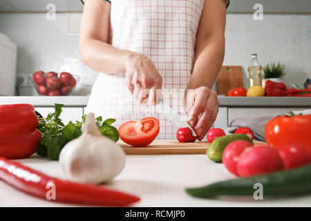 La cuisine du terroir. Une femme dans la cuisine coupe les radis sur une planche de bois. Les aliments frais et sain Banque D'Images