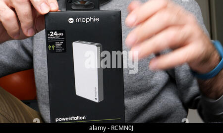 PARIS, FRANCE - DEC 17, 2018 : Man unboxing Amazon boîte carton contanining powersation Mophie haute capacité USB Batterie universelle Banque D'Images