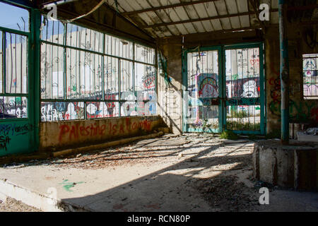 Un bâtiment détruit par les raids israéliens et les bombes vu à côté du mur de séparation. Le mur de séparation israélien est une barrière de séparation qui sépare la Cisjordanie d'Israël. Banque D'Images