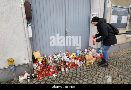 Torgelow, Allemagne. 16 janvier, 2019. Une femme met une bougie devant la maison où une fillette de six ans est décédé le 12.01.2019. Après la mort violente de l'enfant, le beau-père présumé est toujours en fuite. Crédit : Bernd Wüstneck/DPA - ATTENTION : Les noms sur la boîte aux lettres pixeled pour des raisons de droits de la personnalité/dpa/Alamy Live News Banque D'Images