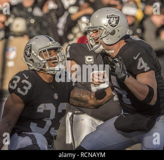 Oakland, Californie, USA. Le 24 décembre, 2016. Oakland Raiders running back DeAndre Washington (33) célèbre avec quarterback touchdown Derek Carr (4) le samedi, Décembre 24, 2016, chez O.co Coliseum à Oakland, Californie. Les raiders défait les Colts 33-25. Crédit : Al Golub/ZUMA/Alamy Fil Live News Banque D'Images