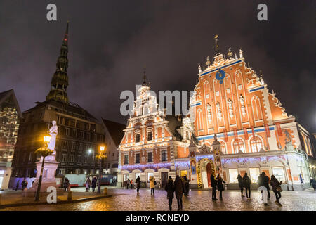 La place de l'Hôtel de ville avec la Maison des Têtes Noires et église Saint Pierre dans la vieille ville de Riga dans la nuit avec un arbre de Noël, la Lettonie Banque D'Images